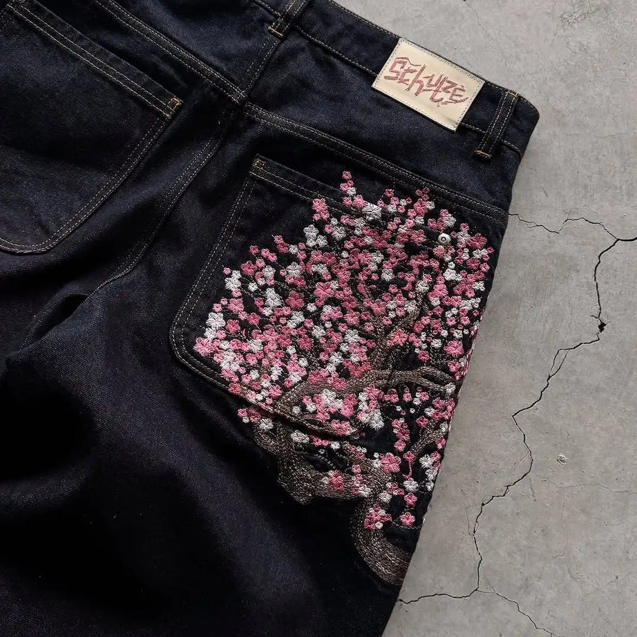 Jean homme brodé Sakura, coupe slim droite, délavage clair, coton stretch, style streetwear décontracté, plusieurs tailles disponibles.