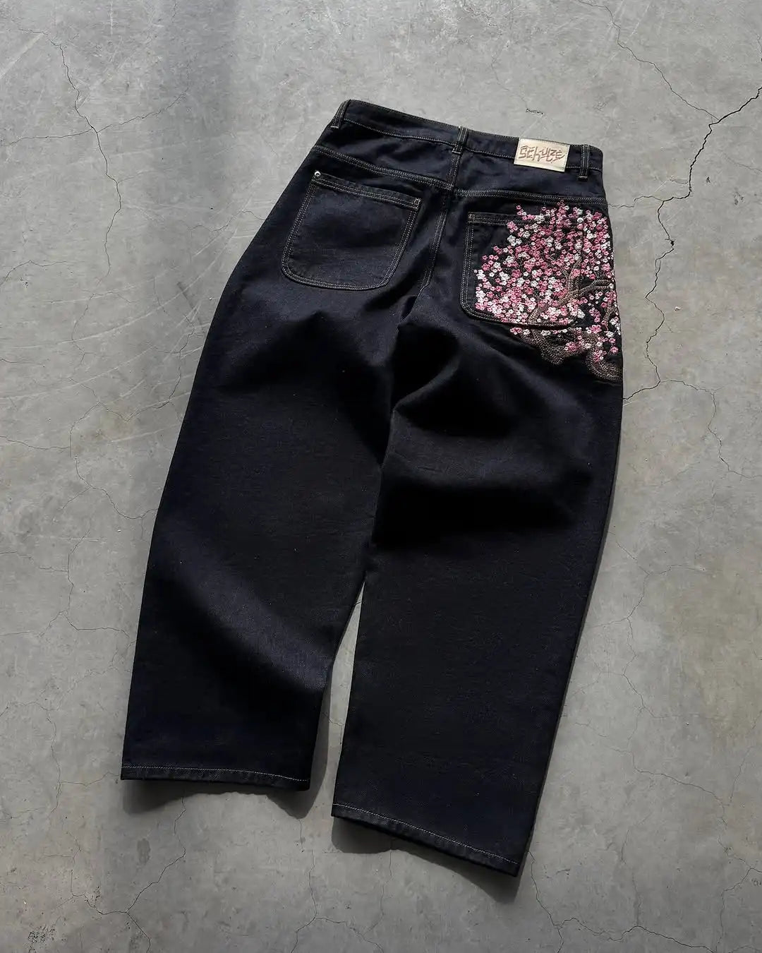 Jean homme brodé Sakura, coupe slim droite, délavage clair, coton stretch, style streetwear décontracté, plusieurs tailles disponibles.