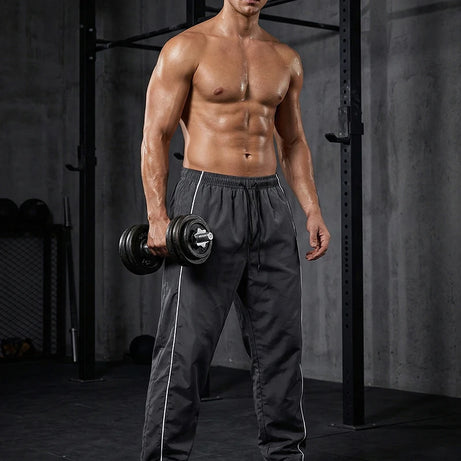 Pantalon de sport tendance pour homme, avec lignes, idéal pour la salle de sport et la course à pied. Poches latérales, séchage rapide et respirant.