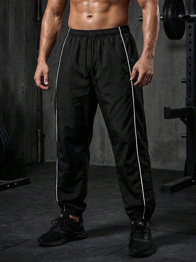 Pantalon de sport tendance pour homme, avec lignes, idéal pour la salle de sport et la course à pied. Poches latérales, séchage rapide et respirant.