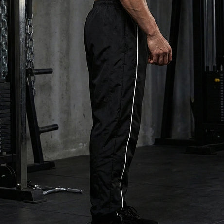 Pantalon de sport tendance pour homme, avec lignes, idéal pour la salle de sport et la course à pied. Poches latérales, séchage rapide et respirant.