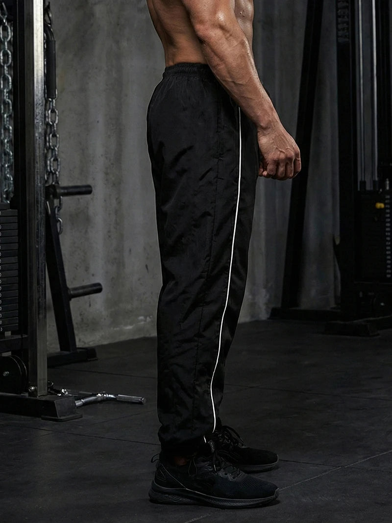 Pantalon de sport tendance pour homme, avec lignes, idéal pour la salle de sport et la course à pied. Poches latérales, séchage rapide et respirant.